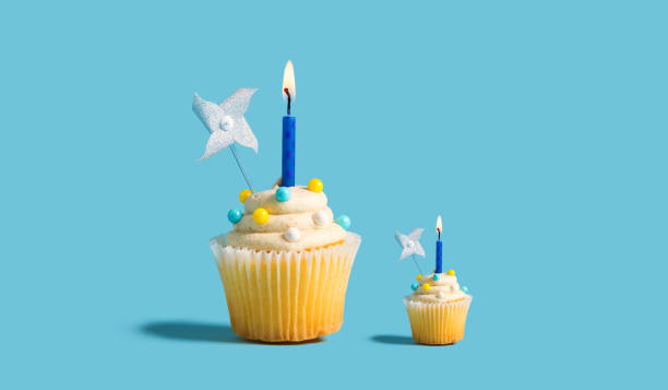 istock Big and small cupcakes with lit candles 1160259518