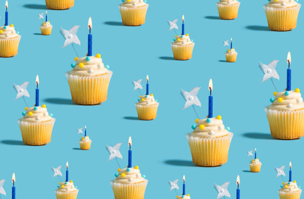 istock Big and small cupcakes with lit candles 1160259528