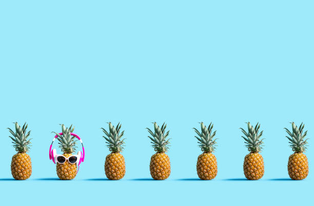 One out unique pineapple wearing headphones on a solid color background