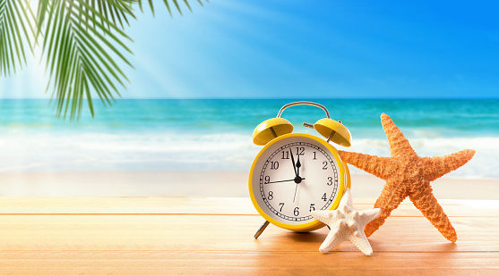 Clock showing nearly 12 on the tropical beach