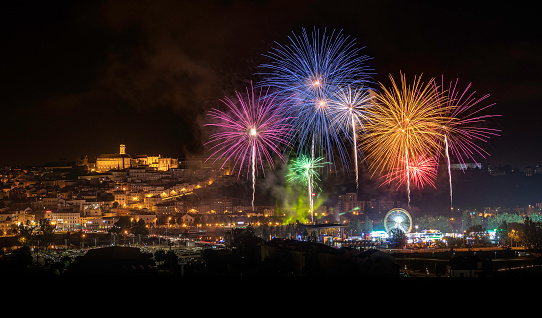 Coimbra, Portugal - July 4, 2019: Panoramic view of the city of Coimbra, Portugal, with the firework show during the city festivities in 2019.