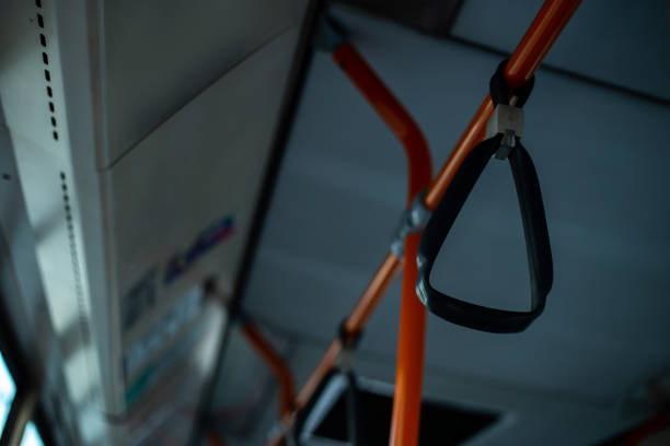 istock Plastic grip handles on bars in bus interior – Orange metallic hand rails in the public transport – Comfortable and practical mean of travel in the city 1160264108