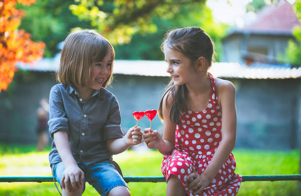 crianças com os pirulitos que têm o divertimento - child valentines day candy eating - fotografias e filmes do acervo