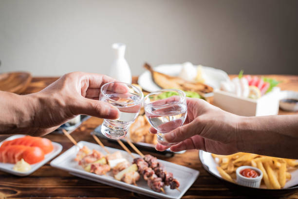 toasting with japanese sake and izakaya popular plates toasting with japanese sake and izakaya popular plates saki photos stock pictures, royalty-free photos & images