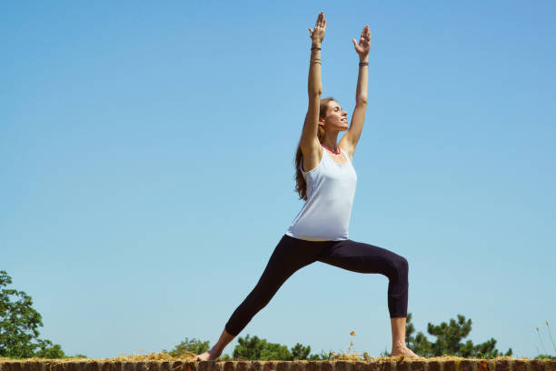 Woman training yoga against the blue sky
