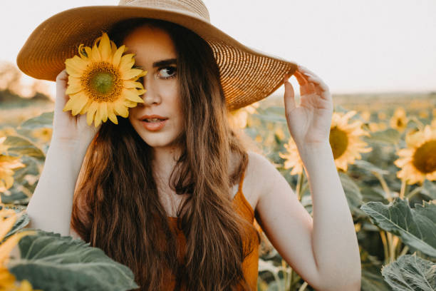 istock Young woman holding a sunflower 1160277191