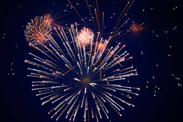 istock Cheap sparkling fireworks, red and white, in the night sky 1160277440