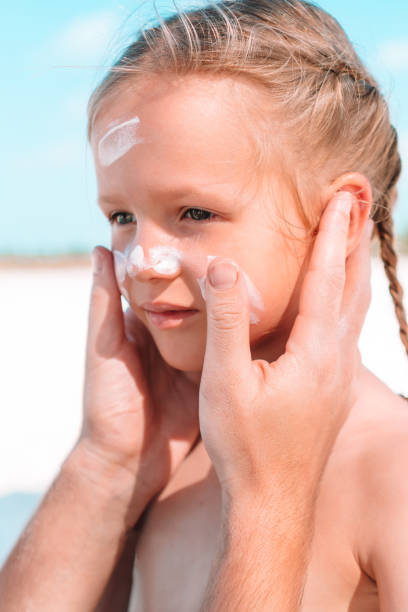 istock Father applying sun cream to daughter nose. 1160278608