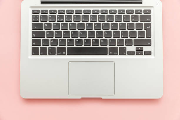 istock Keyboard laptop computer isolated on pink pastel desk background. Modern Information technology and sofware advances 1160281491