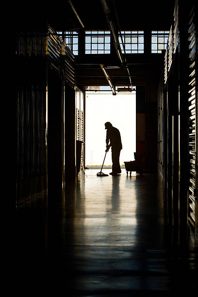 Silhouette of a man mopping a floor in the evening Silhouette of a man moping warehouse floor superintendent stock pictures, royalty-free photos & images