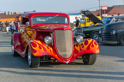 Dartmouth, Nova Scotia, Canada - July 4, 2019 : 1934 Ford 3 window coupe at weekly summer A&W Cruise-In at Woodside ferry terminal parking lot. People walk among the vintage cars on a pleasant summer evening.