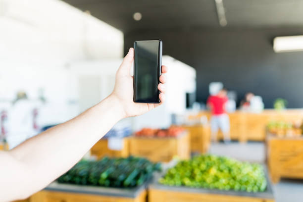 istock Hand Using Smartphone In Blur Supermarket 1160290794