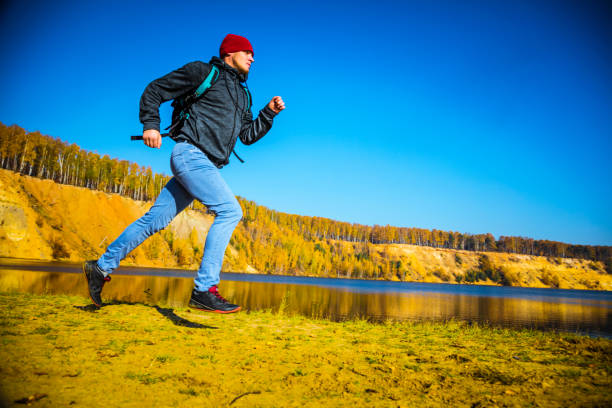 istock Running around the autumn lake and forest - low angle view 1160297087