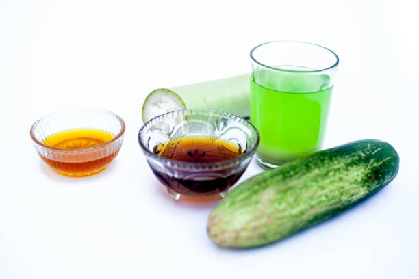 istock Bottle gourd face pack isolated on white i.e. Bottle gourd or lauki juice well mixed with cucumber, and honey in a glass bowl with entire raw ingredients. 1160297183