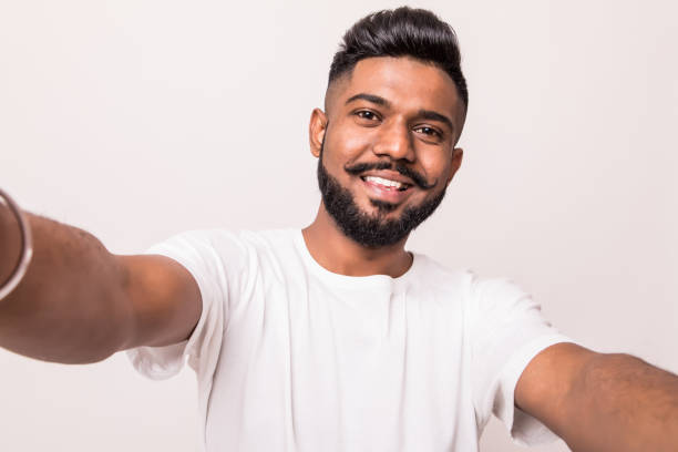 istock Young pretty indian man taking selfie isolated on white background 1160298998