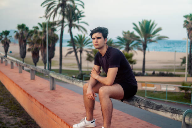 istock Young athletic man after running at park with skyscrapers background 1160299118