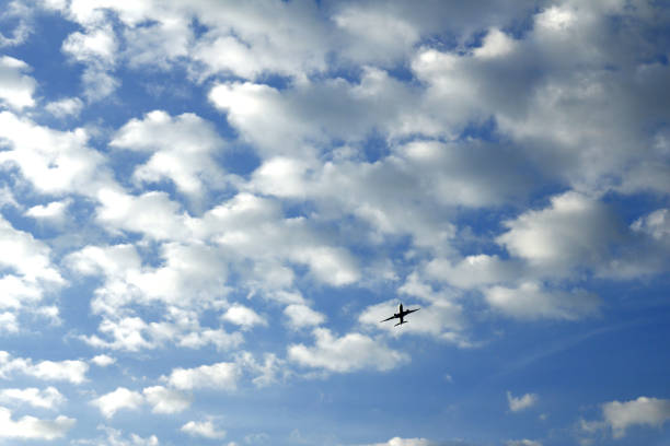 istock Airplane flying and clear blue sky with white clouds 1160304858