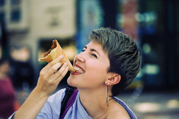 istock Beautiful woman eating ice-cream 1160305707