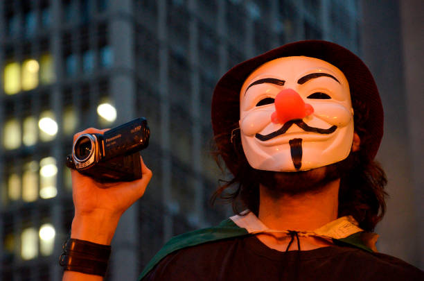 A brazilian protester using a Guy Fawkes mask Porto Alegre, Brazil - 03/31/2013: A brazilian protester using a Guy Fawkes mask with a camera vendetta stock pictures, royalty-free photos & images