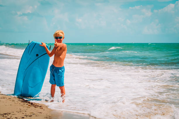 istock happy cute boy enjoy surfing at sea beach 1160314091