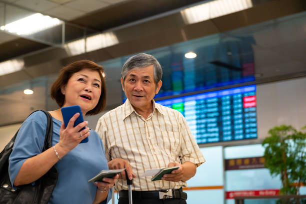 istock Elderly couple talking while standing at airport 1160318727