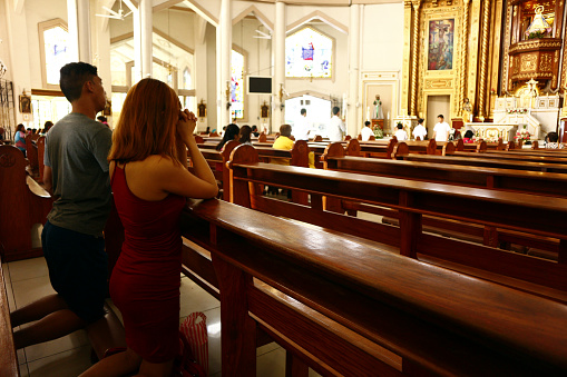 ANTIPOLO CITY, PHILIPPINES – JULY 3, 2019: Catholic devotees kneel and pray inside the Antipolo Cathedral or the Our Lady of Peace and Safe Voyage church.