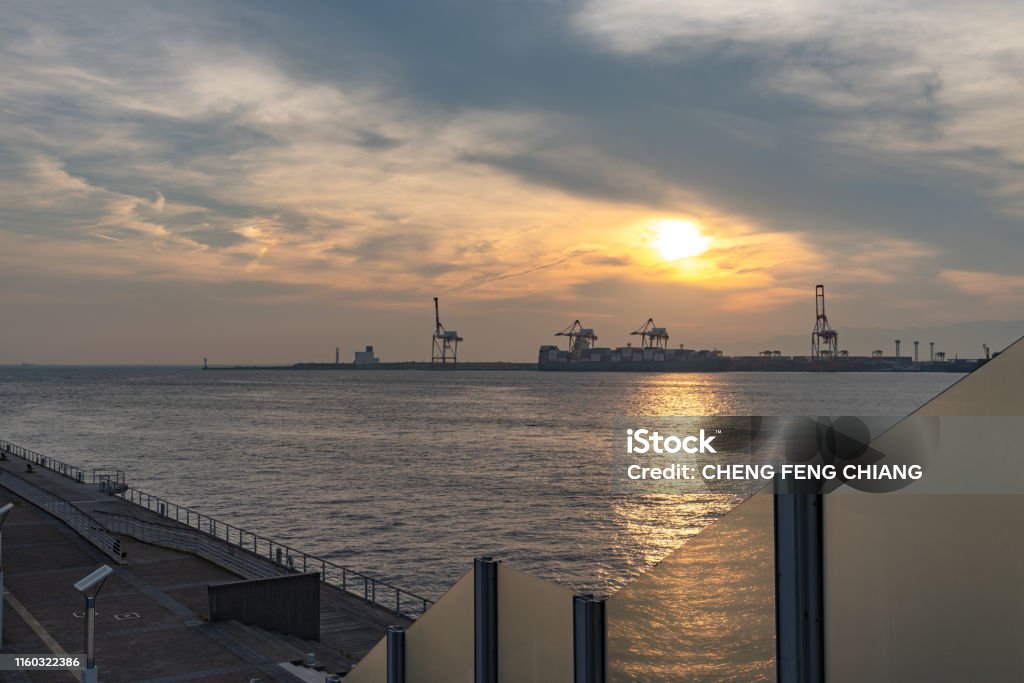 Osaka bay with Yumeshima island on background Osaka bay with Yumeshima island on background in summer sun set time, view from Osaka metro Cosmosquare train station park promenade Architecture Stock Photo