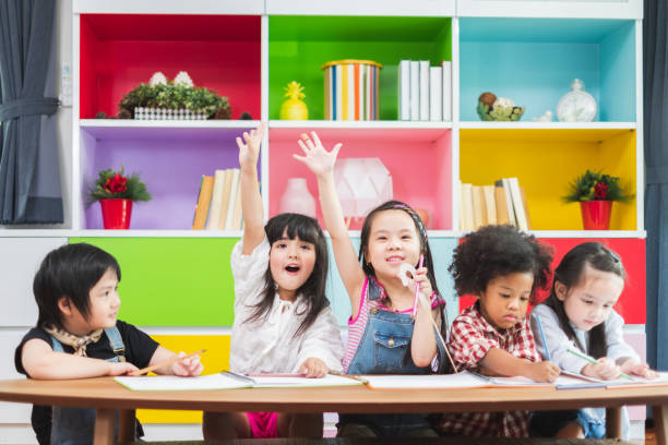 istock Group diversity kids studying at school, rising hands for answer and question in classroom, kids education concept 1160323269