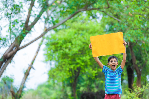 istock indian child holding poster 1160331746