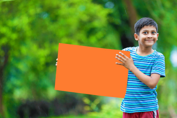 istock indian child holding poster 1160331828