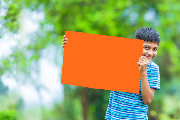 istock indian child holding poster 1160332653