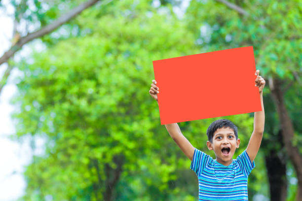 istock indian child holding poster 1160332654