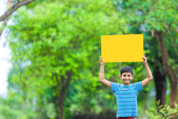 istock indian child holding poster 1160333032