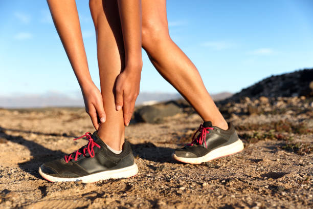 distorsione alla caviglia corsa atleta atleta runner donna - cramping foto e immagini stock