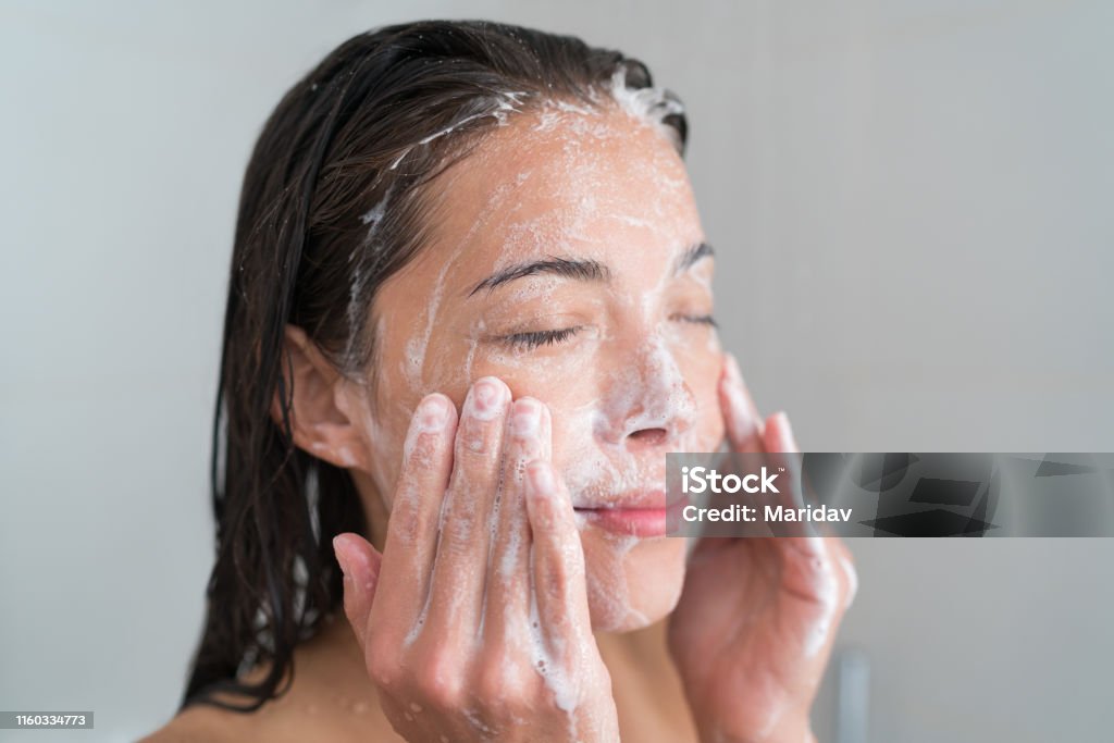 シャワーで洗顔するスキンケアの女性 - 人の顔のロイヤリティフリーストックフォト