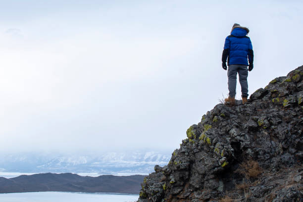 istock Happy man standing on cliff, man looking at landscape view 1160334897