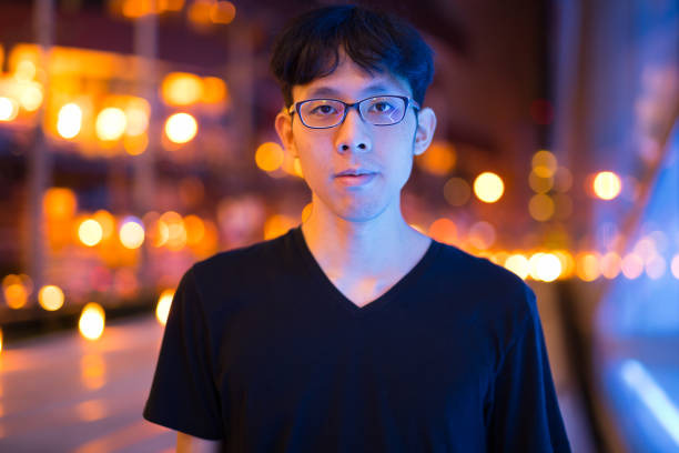 Portrait Of Young Asian Man Outdoors At Night