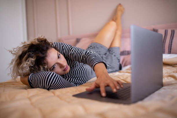 istock Woman using laptop at bedroom 1160339105