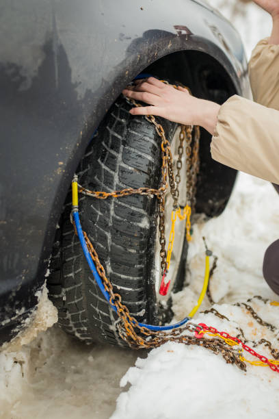 istock Beautiful woman installing snow chain on her car 1160339954