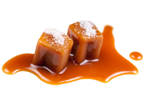 Melted caramel candies and caramel sauce with a salt  isolated on a white background. Close up