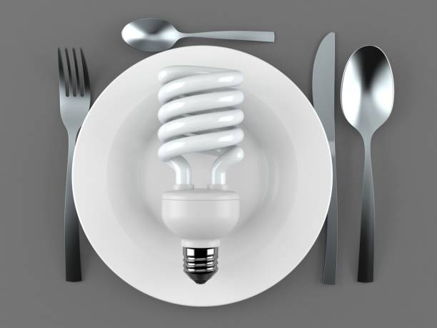 istock Light bulb cfl with plate and cutlery 1160340066