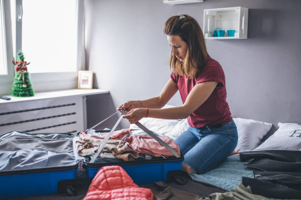 istock Woman packing clothes 1160344131