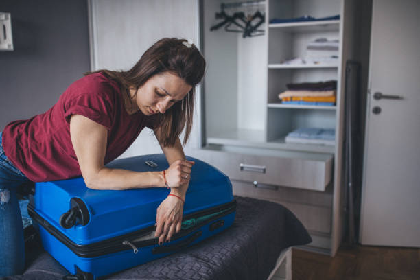 istock Woman closing full suitcase 1160344208