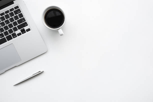 istock White office desk table with laptop computer, cup of coffee and pen. Top view with copy space, flat lay. 1160349913