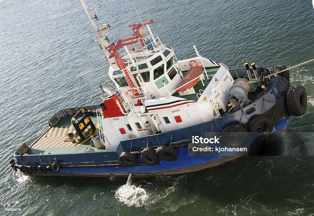 Tug Boat A tug boat pulls a ship into a harbor. Towing Stock Photo