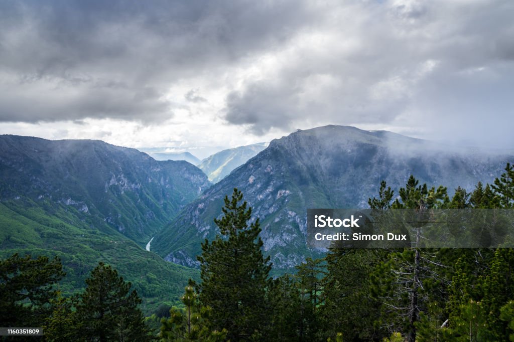 Montenegro, Spectacular view over tara river canyon with dramatic sky of rain clouds and sun from mountain curevac in durmitor national park nature landscape of zabljak Above Stock Photo