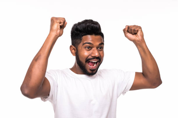 istock I won. Happy young indian man gesturing and smiling while standing against white background 1160355338