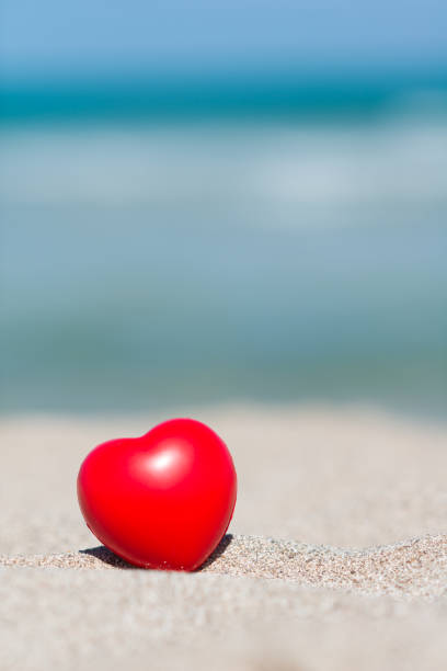 istock Red heart in sand on beach - holiday love 1160357192