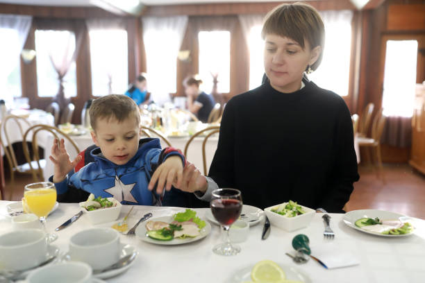 Mother with son have supper Mother with her son have supper in restaurant French kids generally sit at the main table, use the same dishes and eat the same foods as adults. stock pictures, royalty-free photos & images
