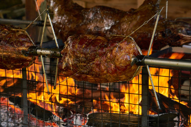 Spit roasting meat over fire stock photo